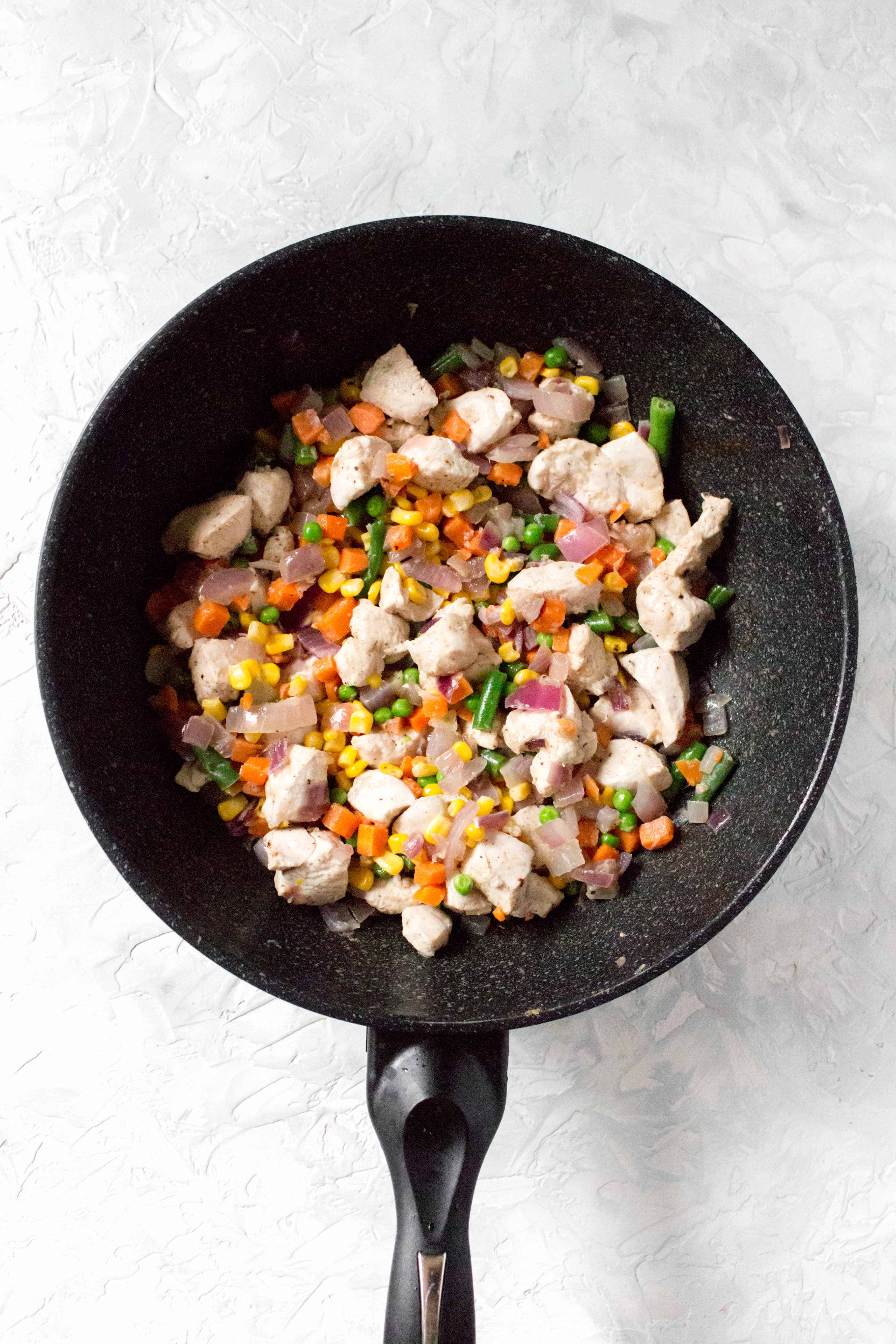 Next, add in your chicken breast. Cook for 5-7 minutes, until it's almost cooked through and then add in the frozen vegetables. Cook until the vegetables have softened.