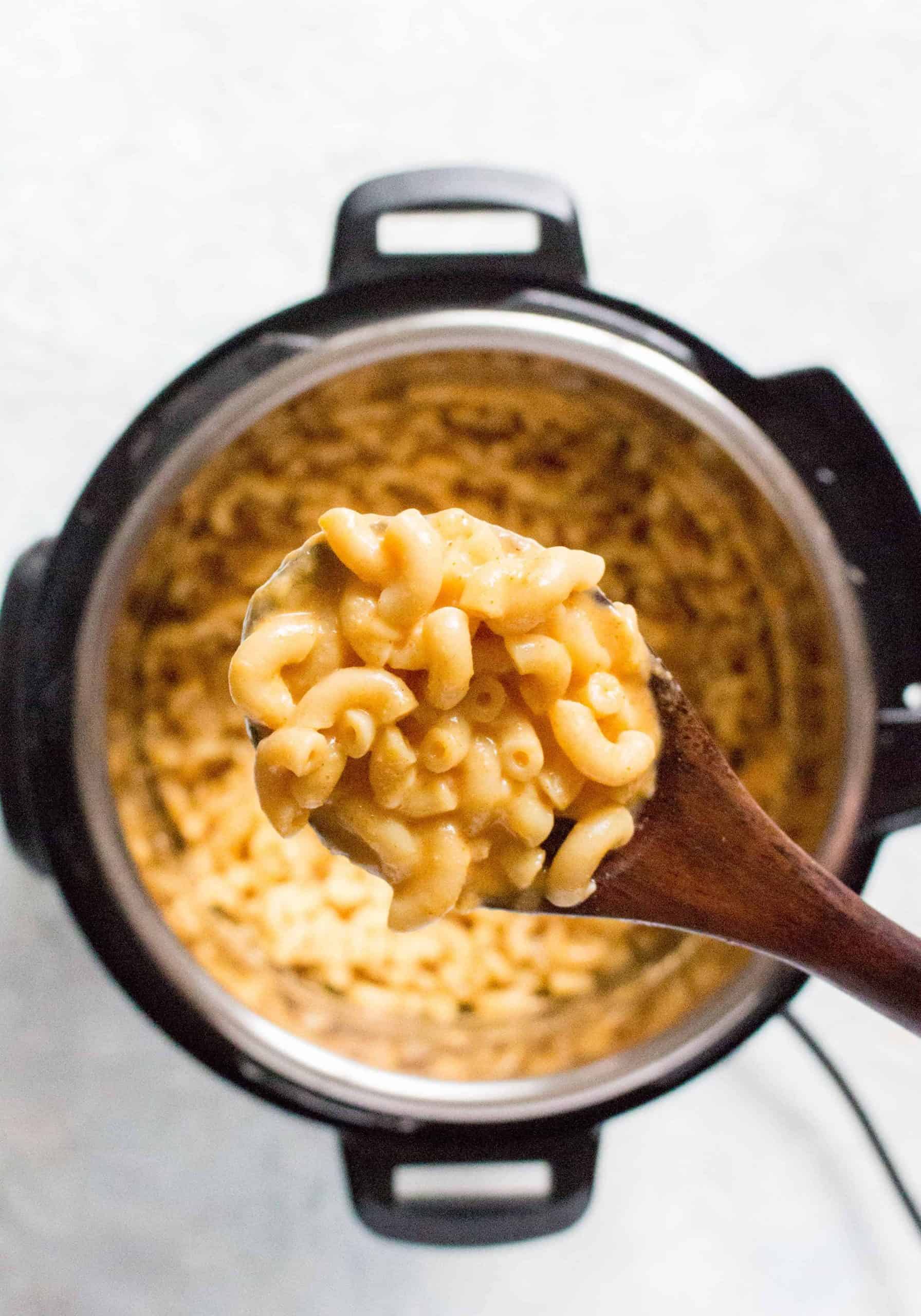 A spoonful of mac and cheese over an instant pot.