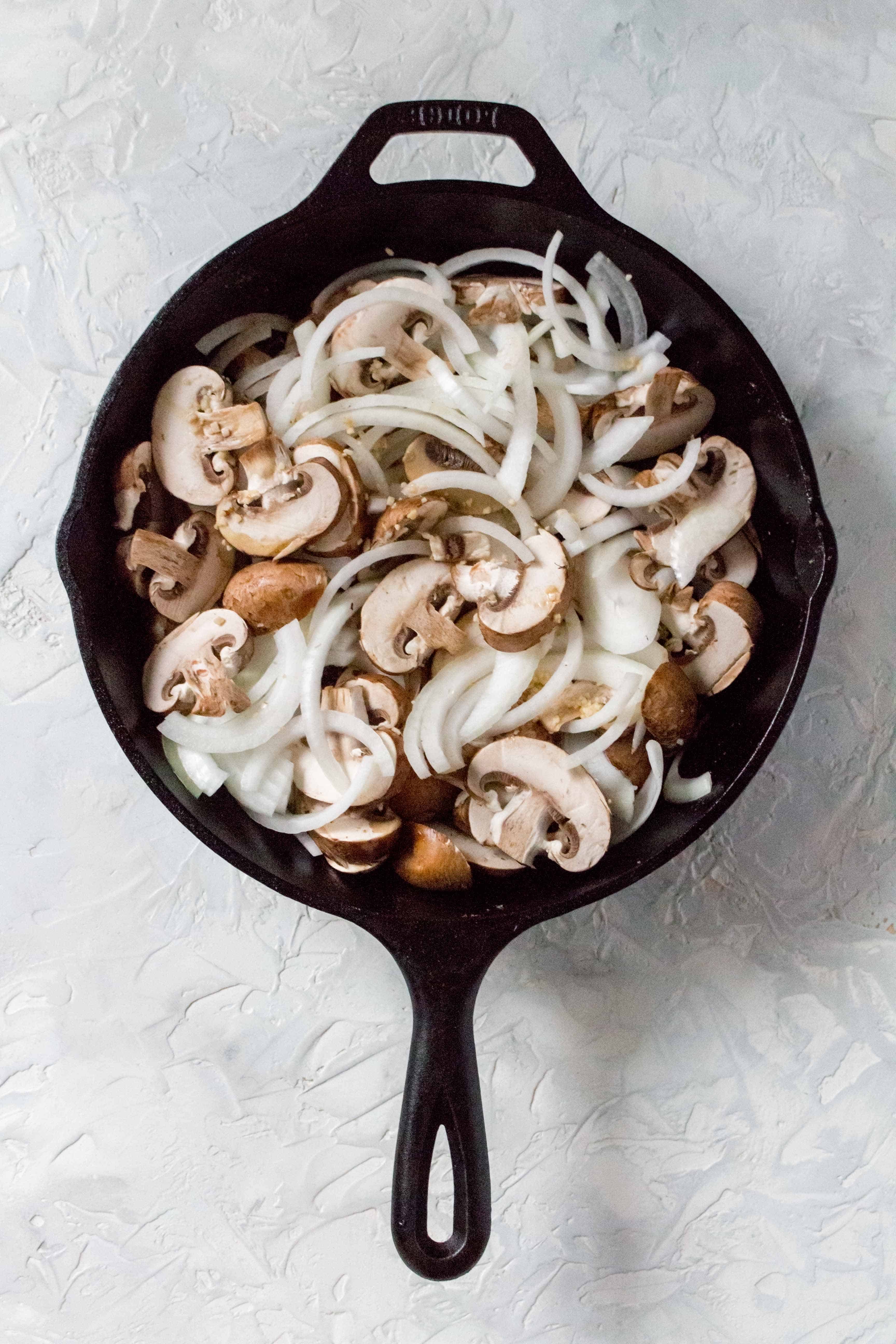 one pot chicken thighs and rice: Back in the cast iron, sauté the mushrooms, onions, and garlic, using the liquid from the olive oil and chicken, for 5 minutes.