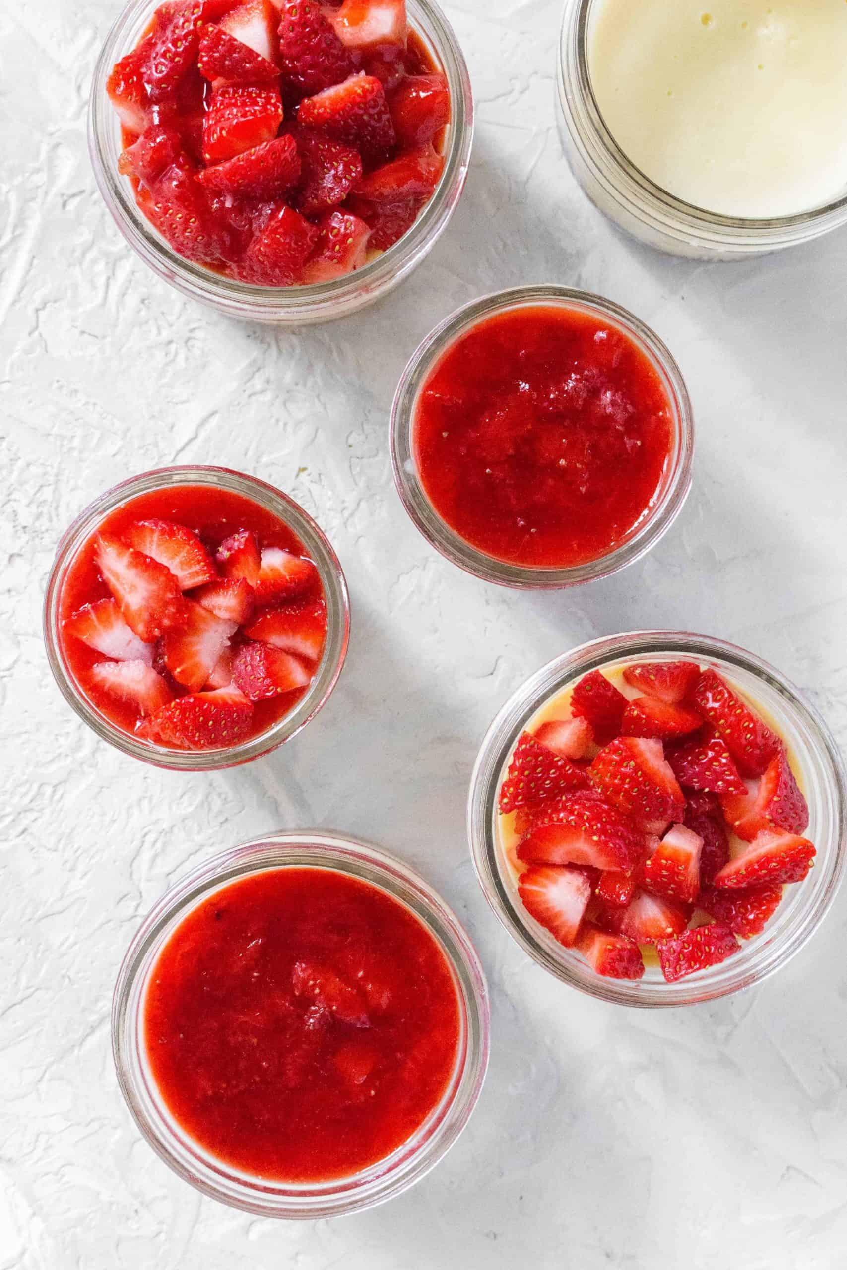 instant pot mason jar cheesecake with different strawberry toppings.