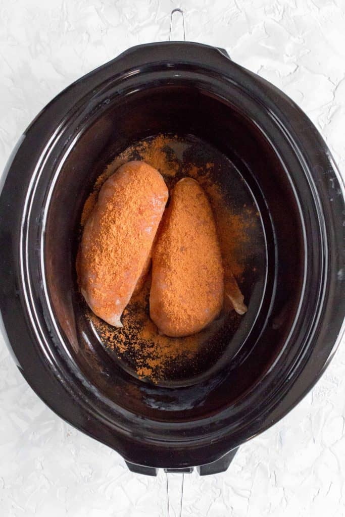 In your slow cooker, add in the chicken breasts, lime juice, and taco seasoning.