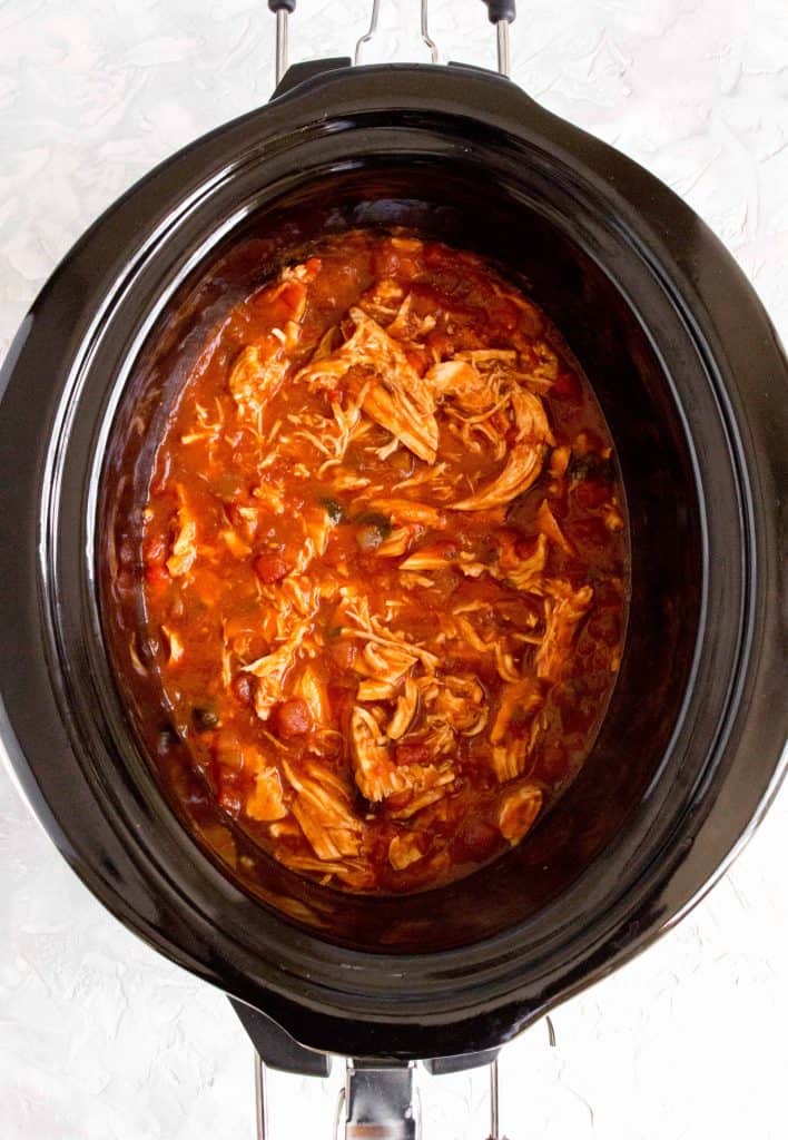 shredded lime cilantro chicken beasts in salsa sauce in a slow cooker