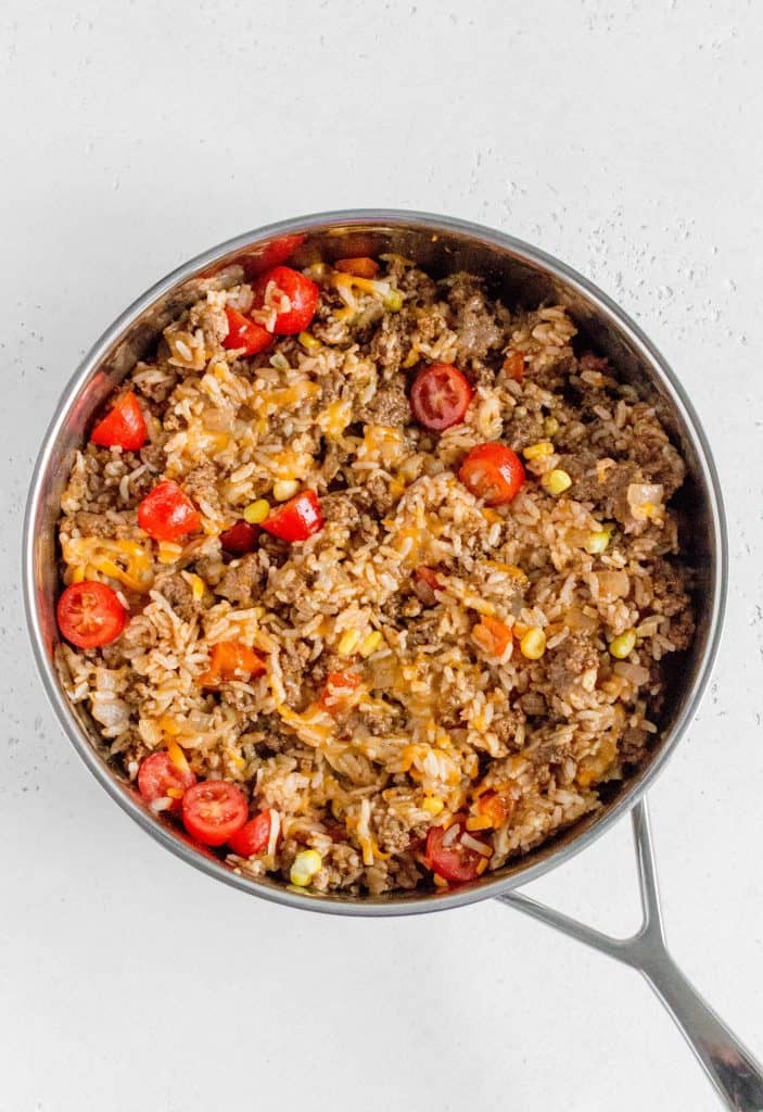 beef with rice corn tomato and cheese in the skillet