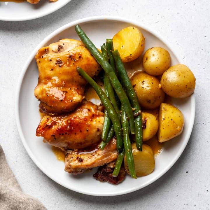 Plate of chicken thighs, green beans, and potatoes.