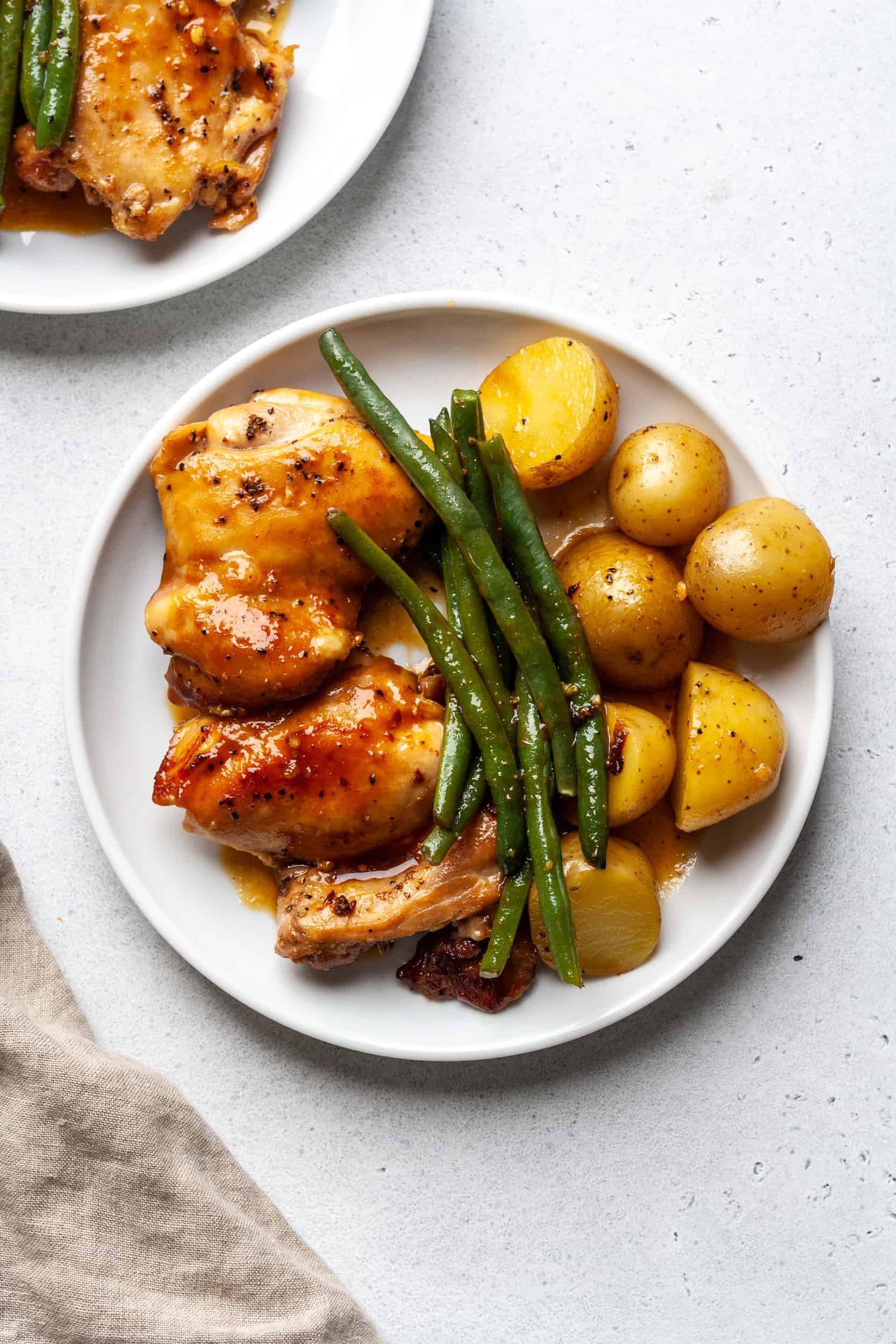 Plate of chicken thighs, green beans, and potatoes.