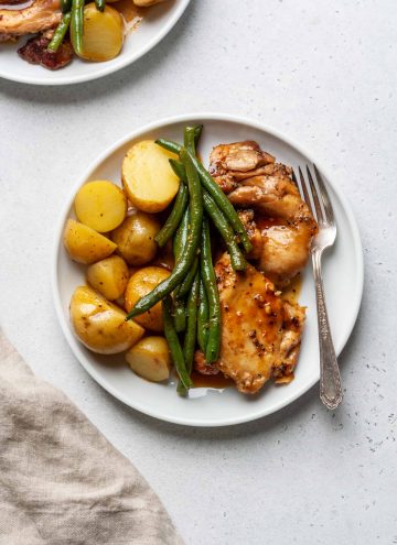 A plate of honey garlic slow cooker chicken and potatoes and green beans.