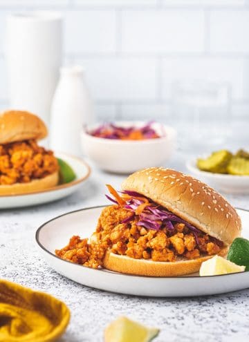 A plate of sloppy joes with ground chicken in a burger bun.