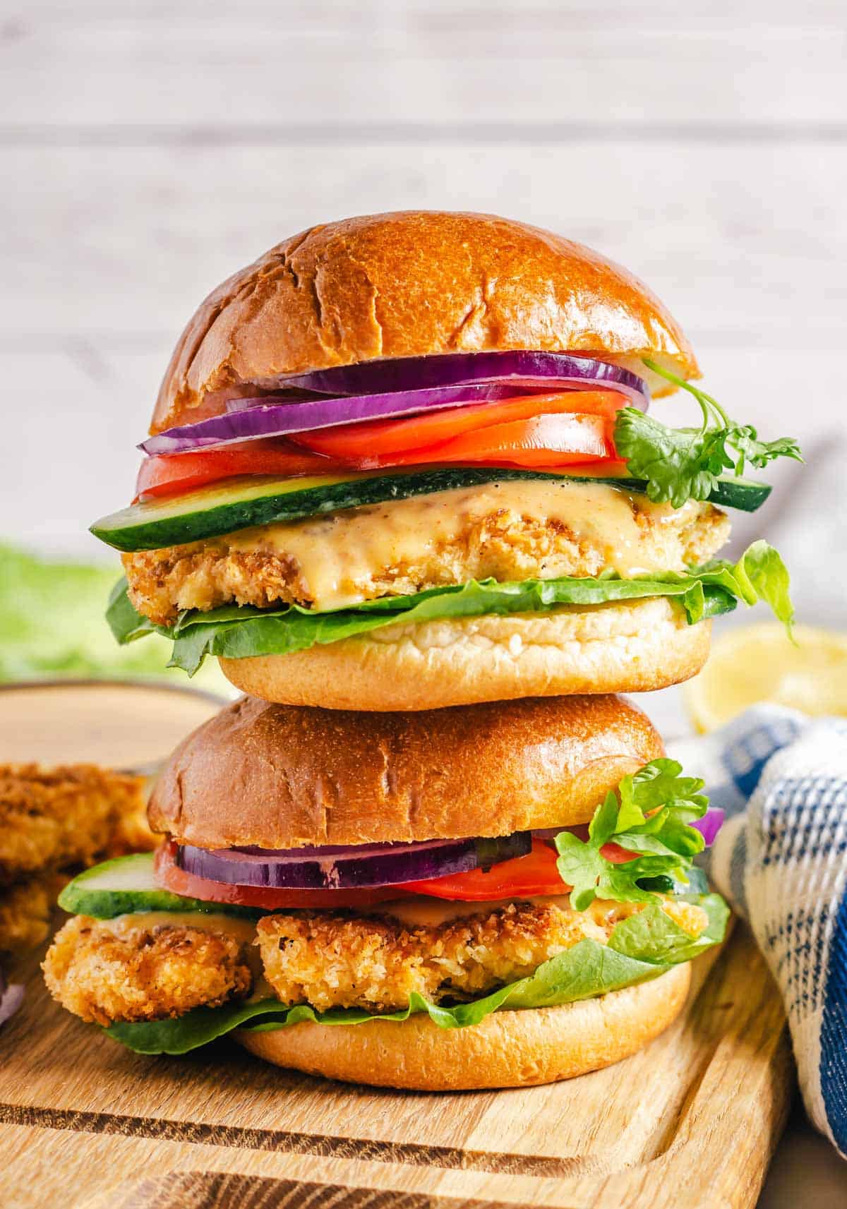 Two crispy chicken sandwiches stacked on top of each other.