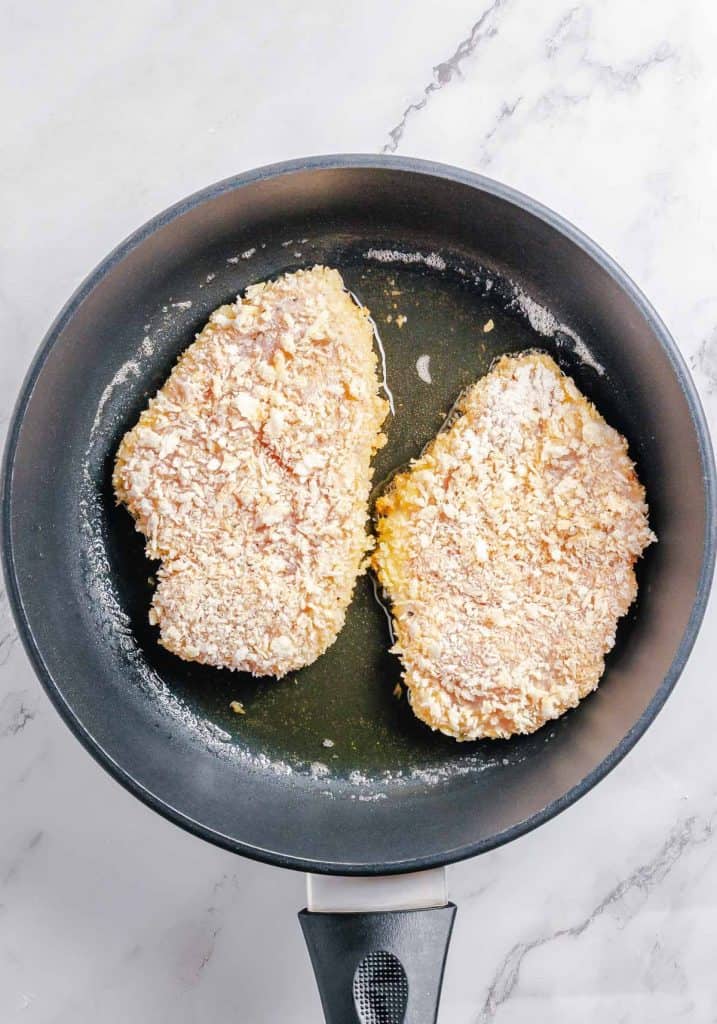 Chicken cutlets fried in a pan.