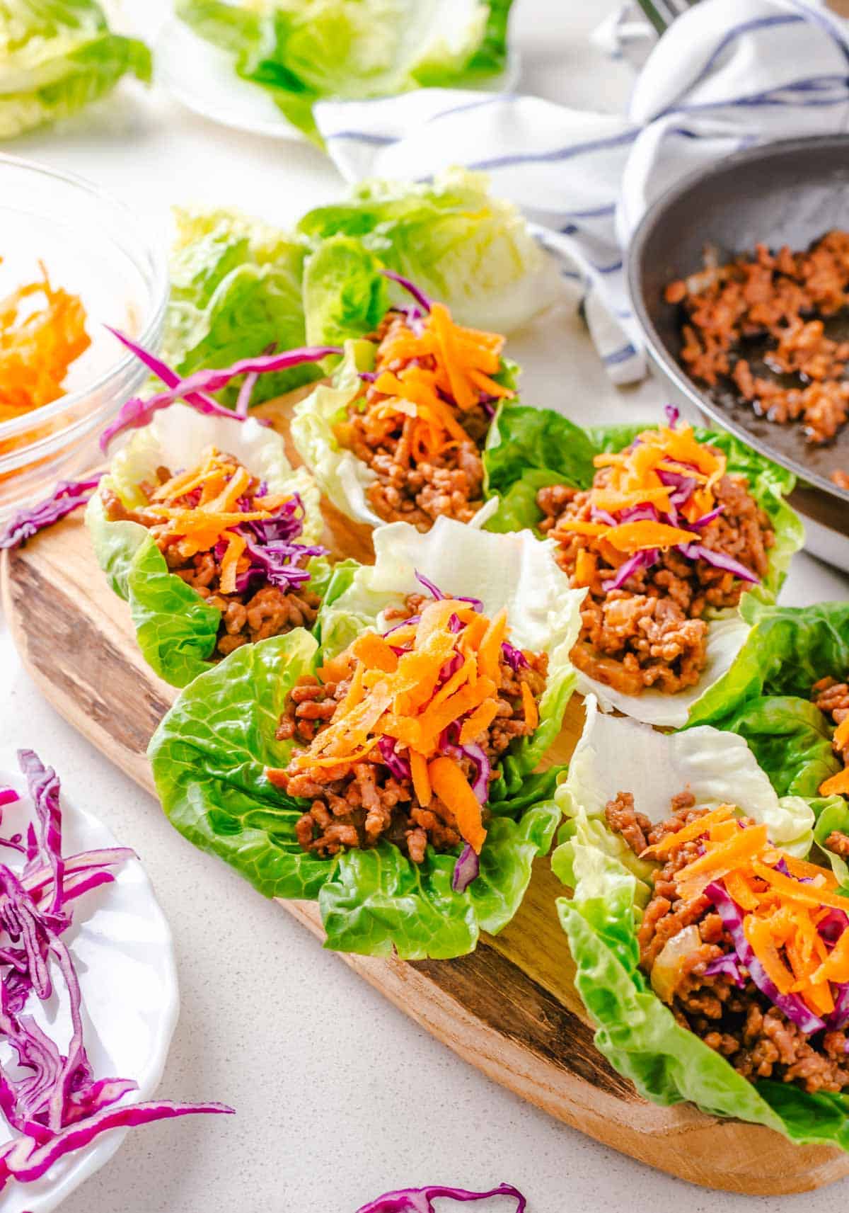 Multiple beef lettuce wraps on a cutting board.