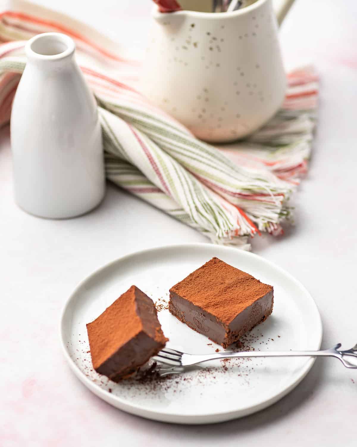 A plate with two pieces of nama chocolate.
