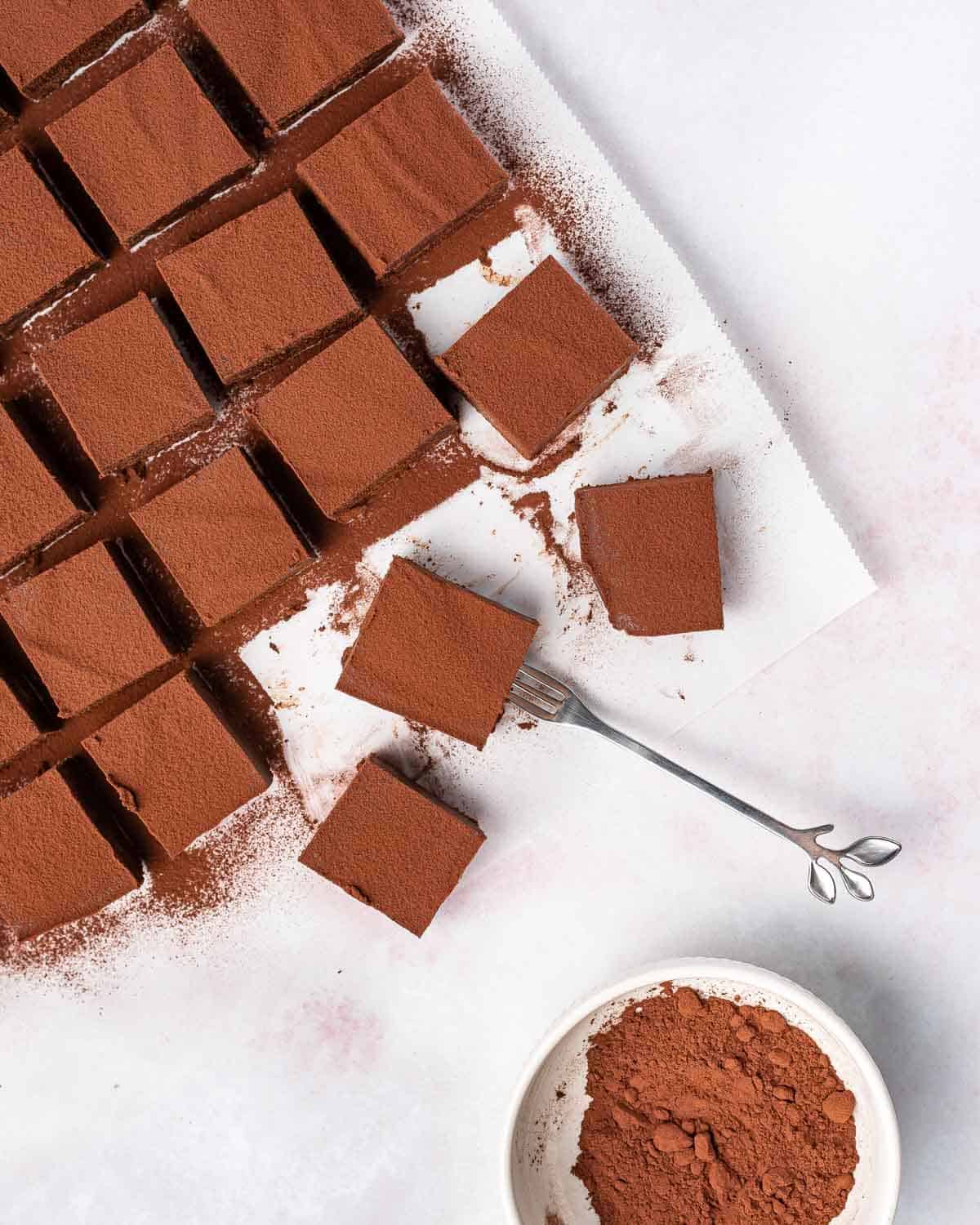 A fork poking into a square piece of nama chocolate.