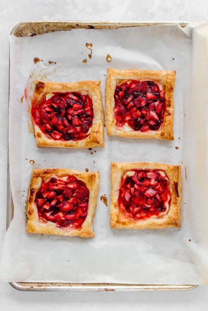 Sheet pan with four strawberry danishes.