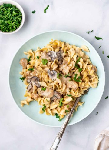 A plate of instant pot chicken stroganoff with a fork in the plate.