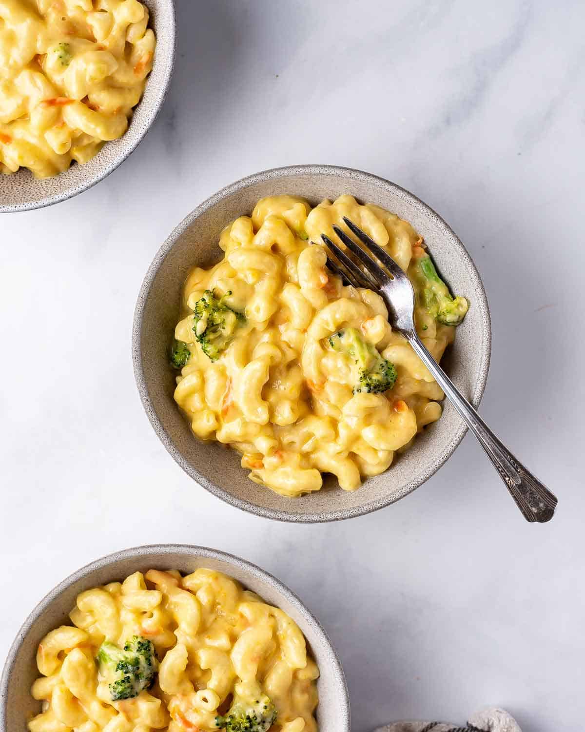A bowl of copycat panera broccoli cheddar mac and cheese with a fork.