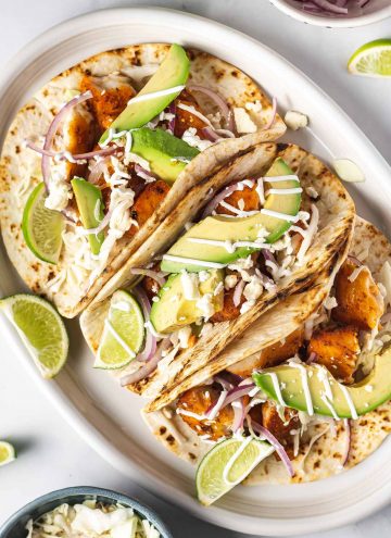 Close up of a platter of air fryer fish tacos with toppings.