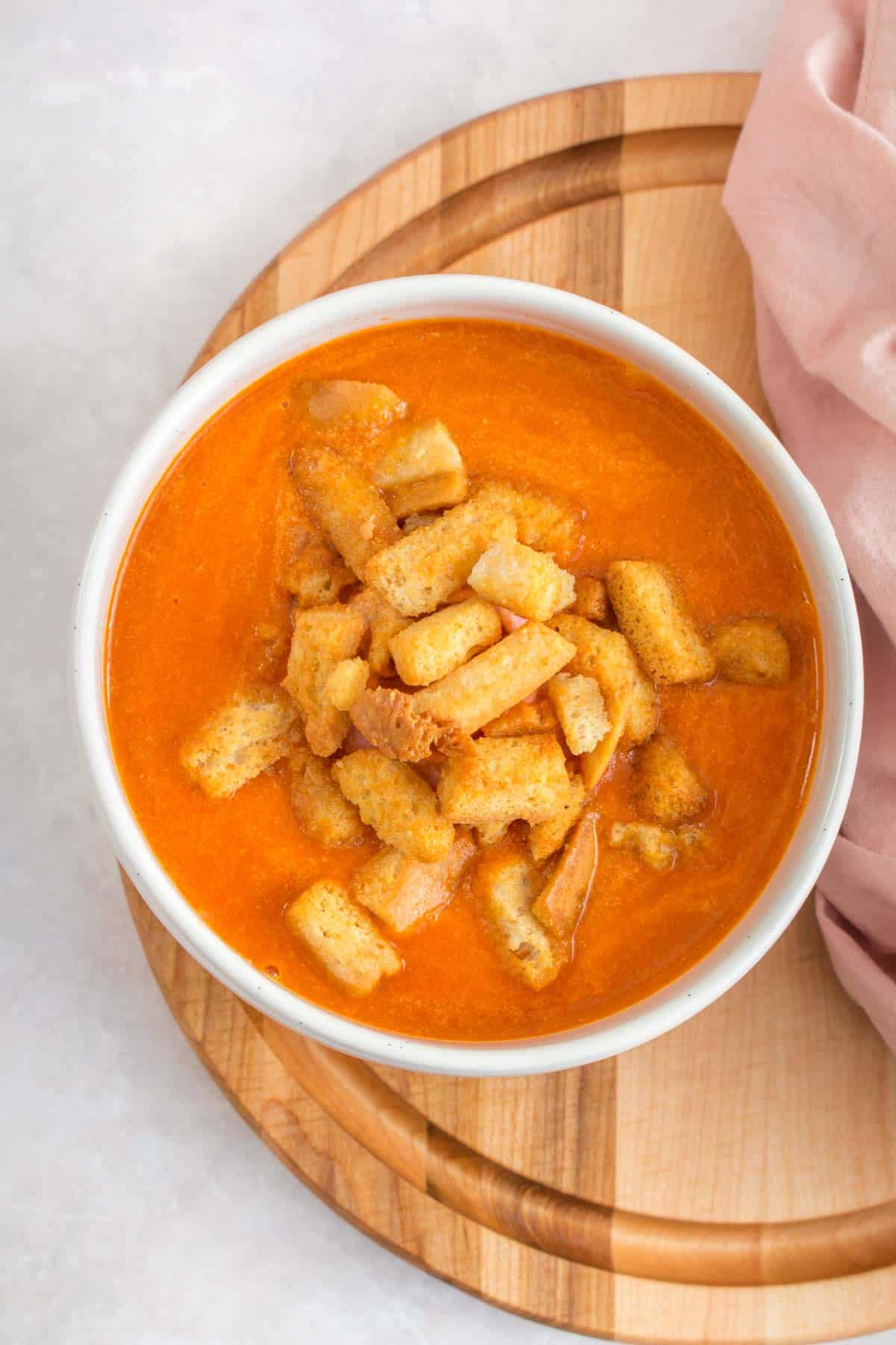 Overhead view of a bowl of bacon tomato soup with croutons. 