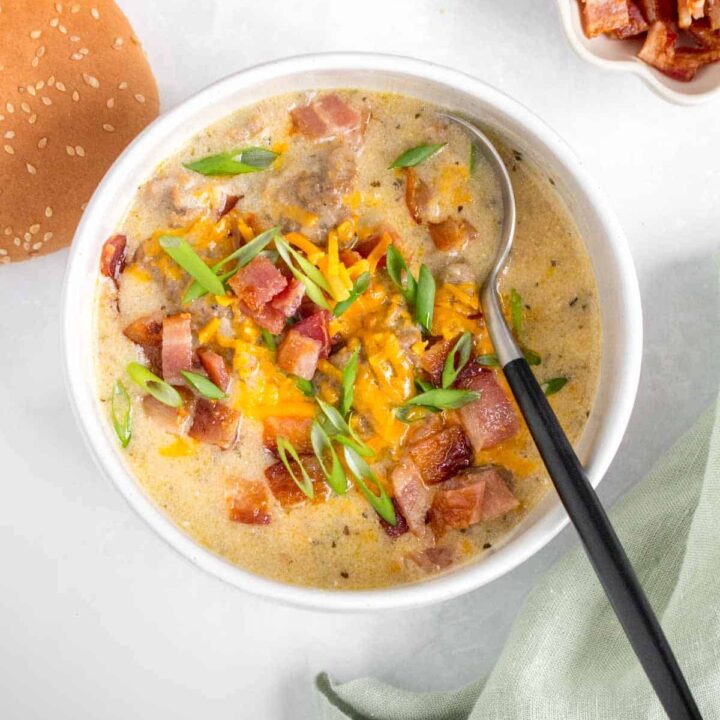 A bowl of instant pot cheeseburger soup with a spoon.