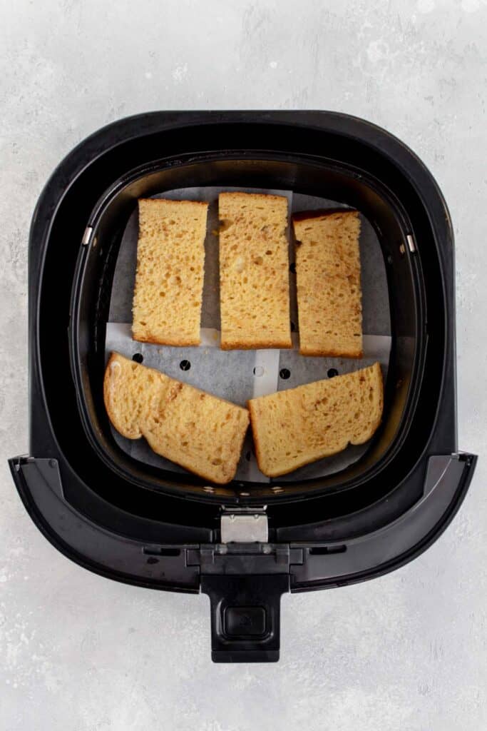 French toast sticks added to an air fryer basket.