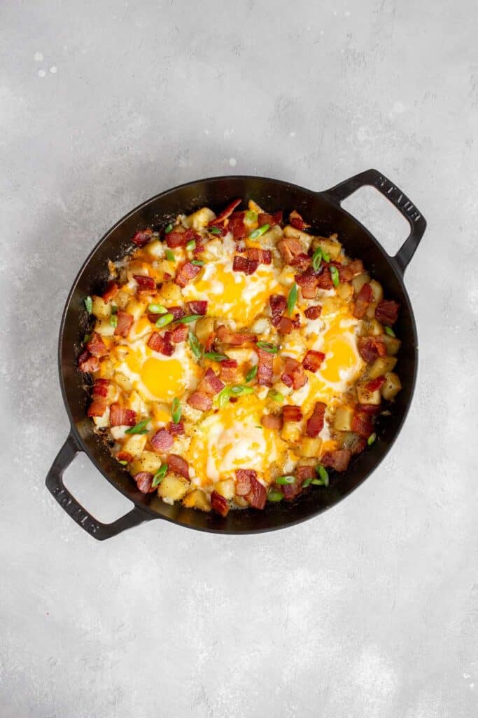 A breakfast skillet with potatoes, eggs, and bacon.