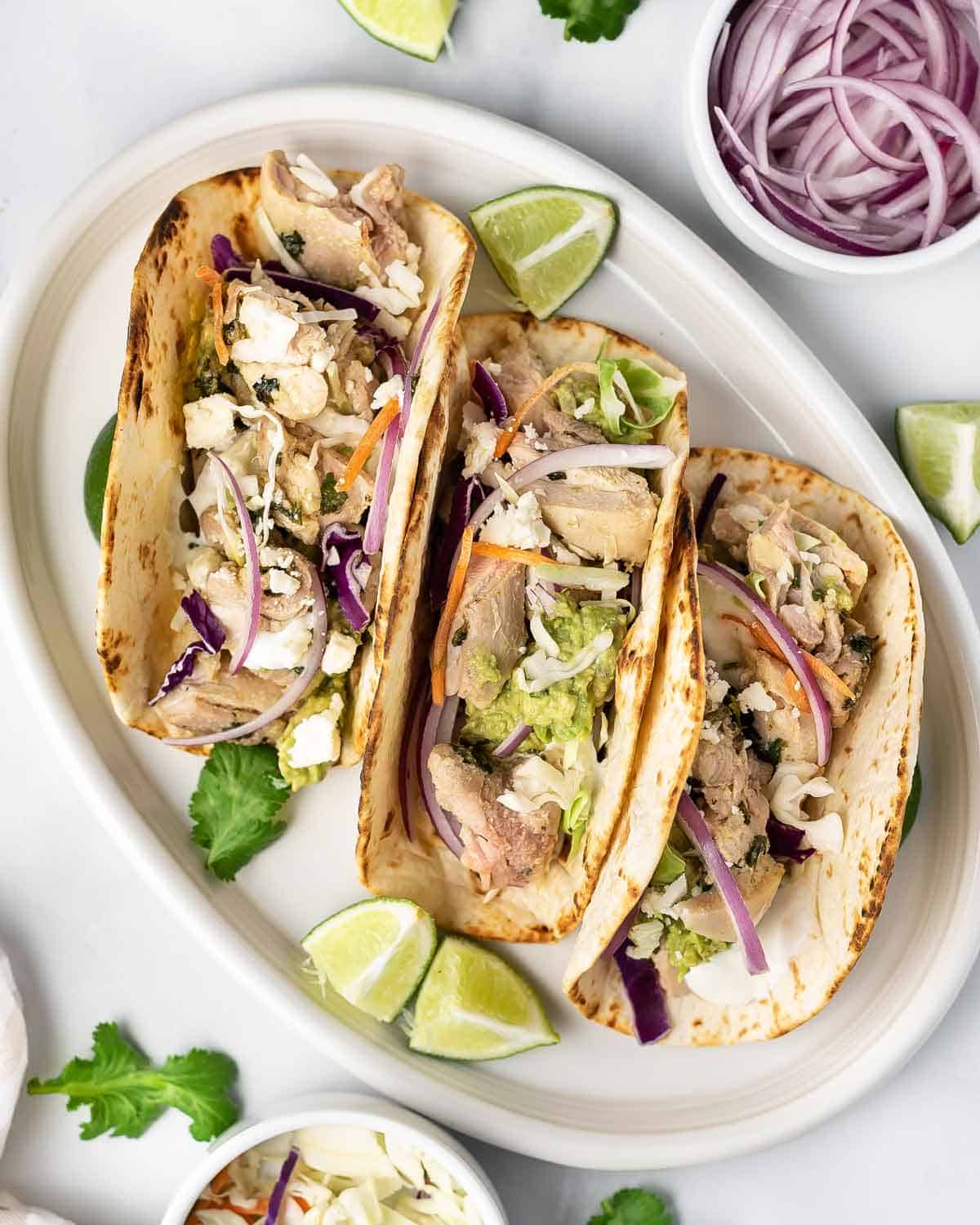 Three cilantro lime chicken tacos in a plate.