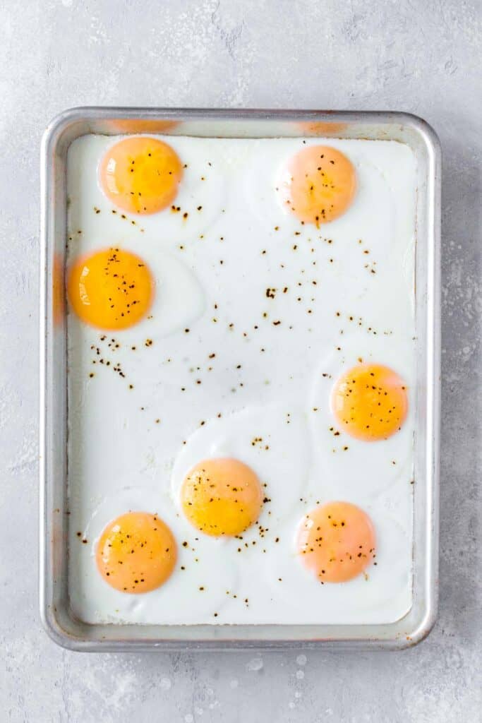 A sheet pan with cooked sunny side up eggs.