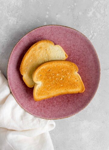 Overhead view of two pieces of toast on a plate.