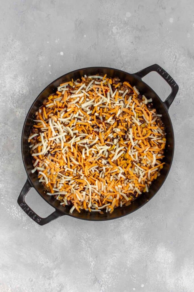 Shredded cheese sprinkled over cooked taco beef.