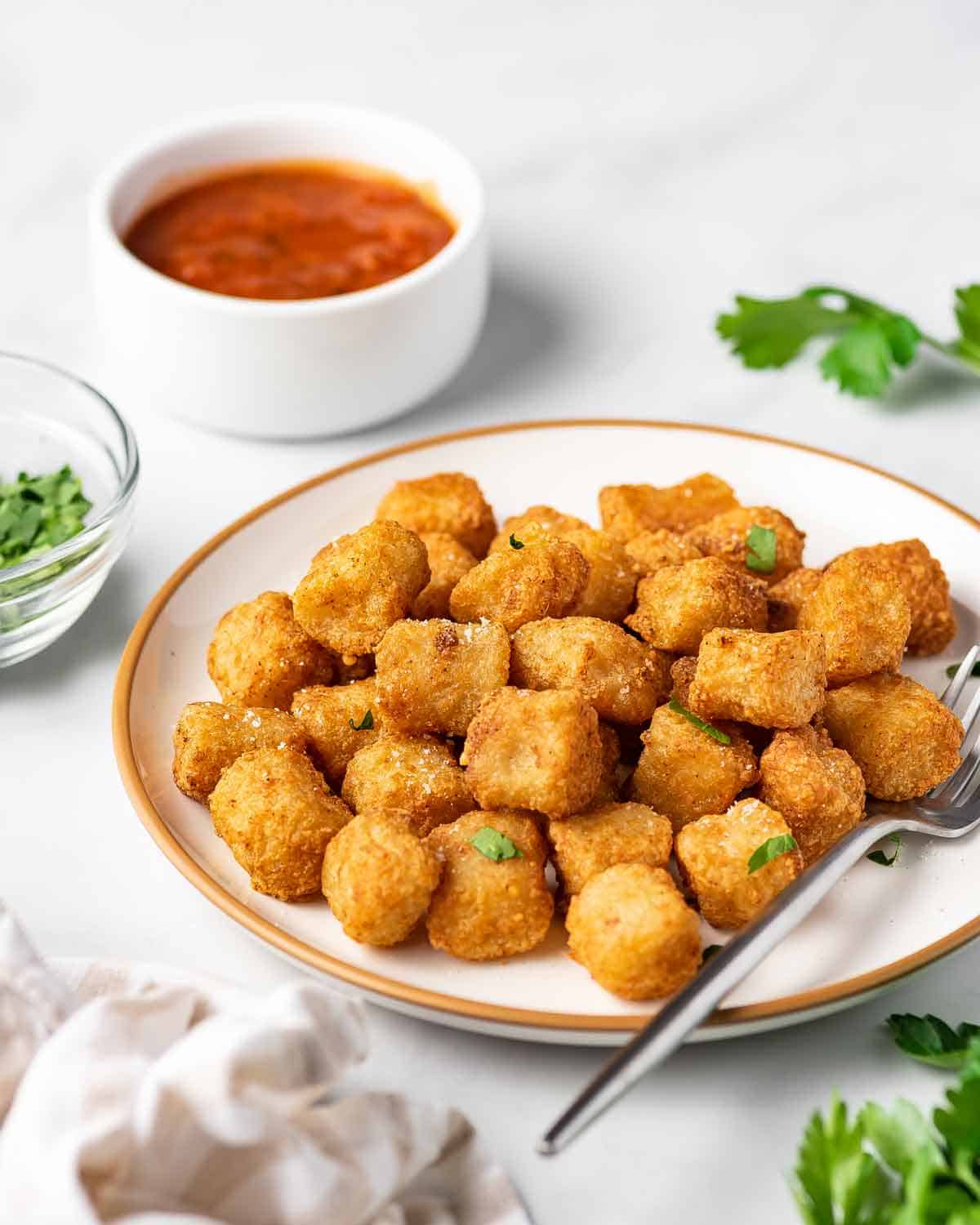 A plate of air fryer cauliflower gnocchi with fresh herbs on top.