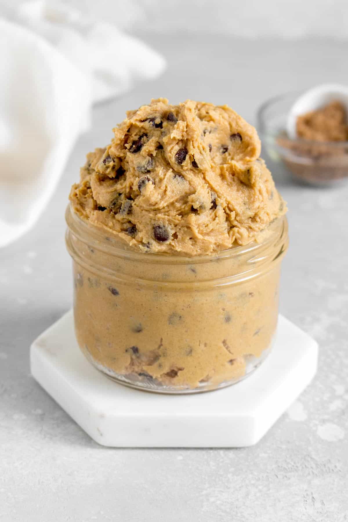 A jar overflowing with edible chocolate chip cookie dough.