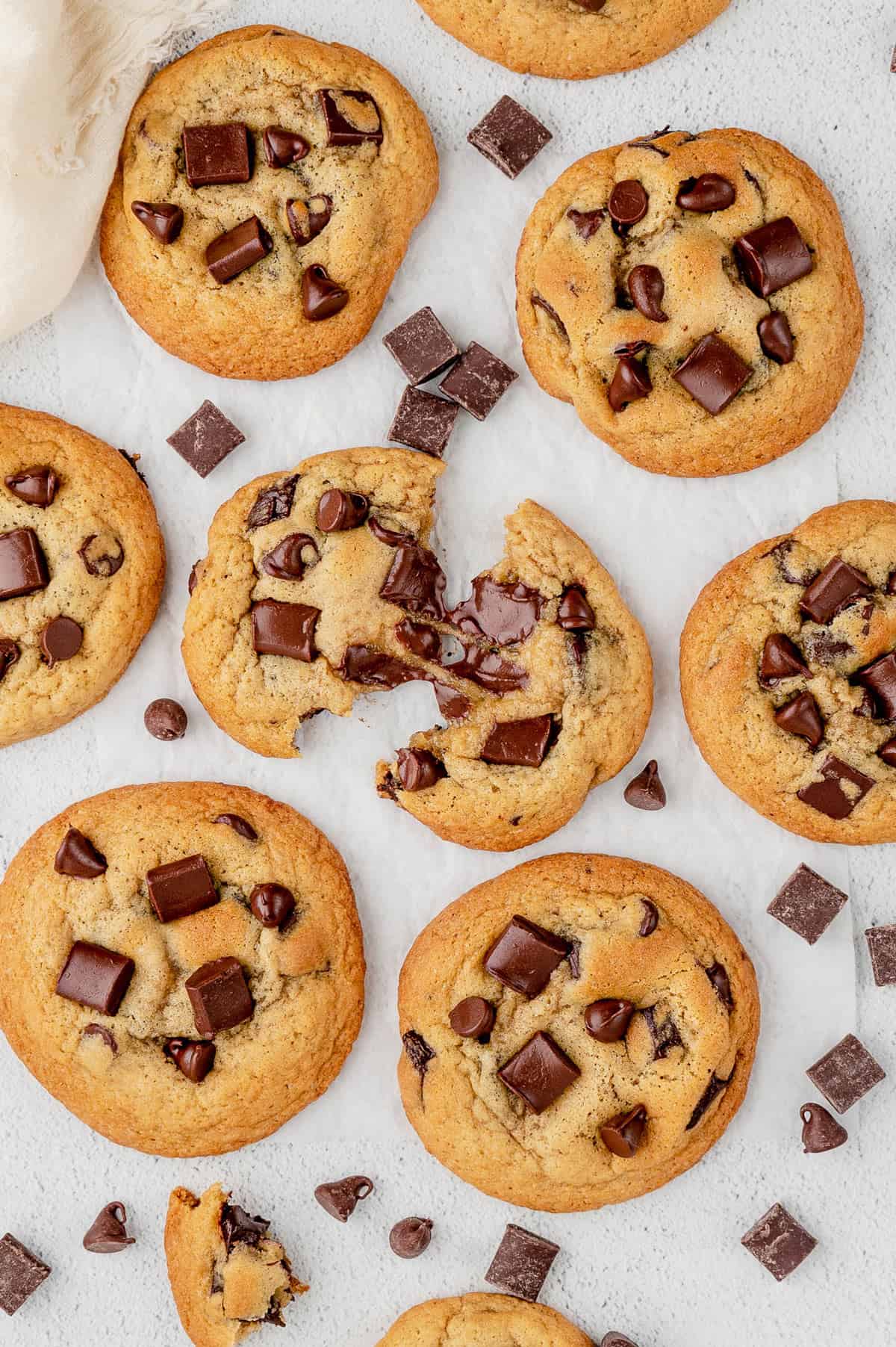 Overhead view of multiple one bowl chocolate chip cookies with one being torn in half.