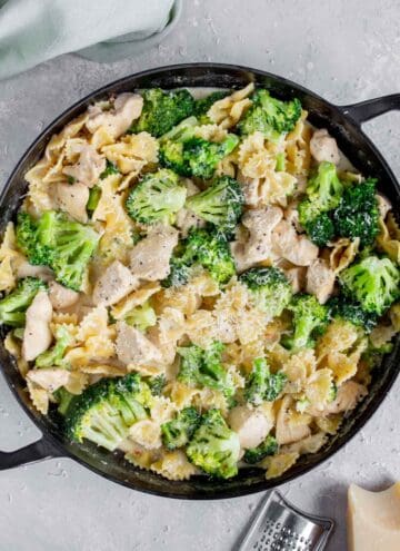 Overhead view of a large round pan of chicken broccoli alfredo.