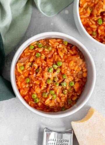 Overhead view of a bowl of one pot orzo with turkey and peas.