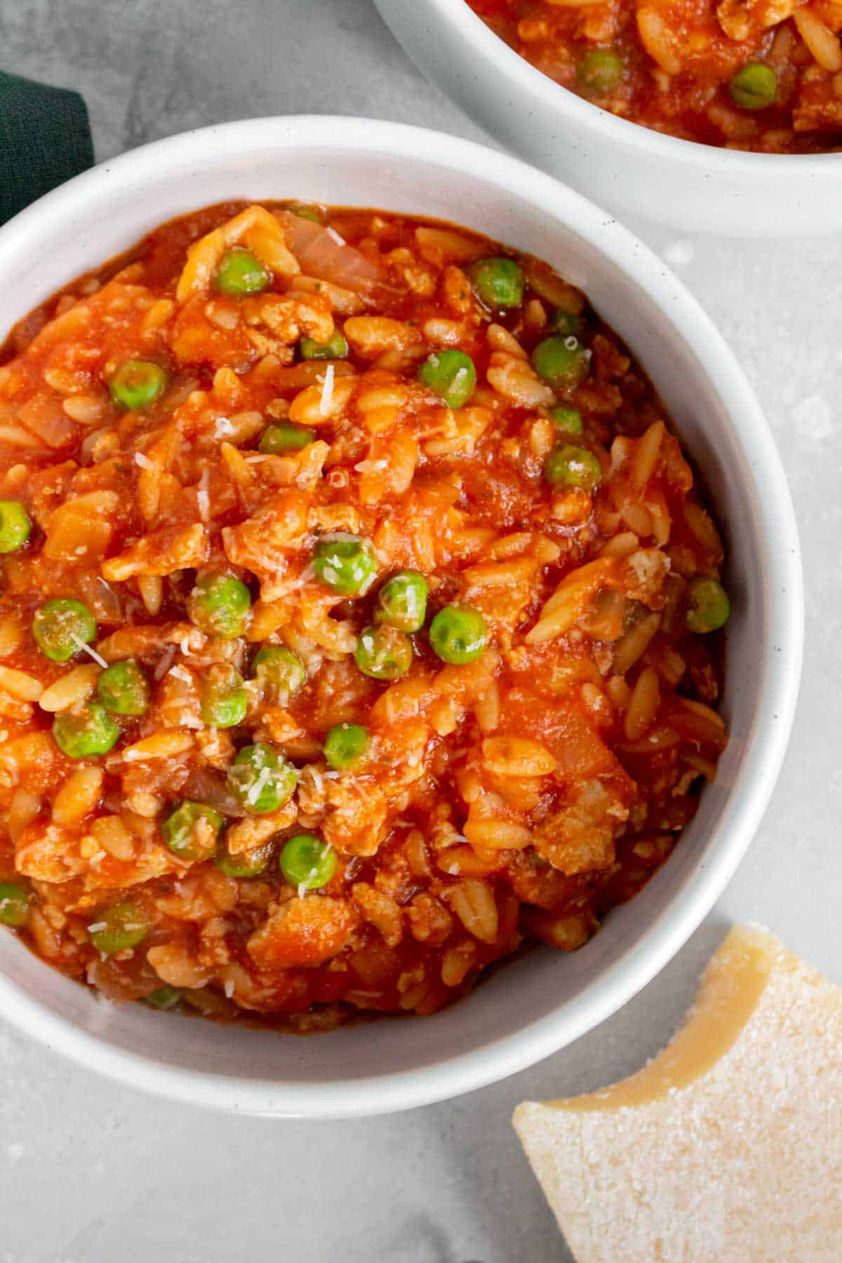 Close up of a bowl of one pot orzo with turkey and peas.