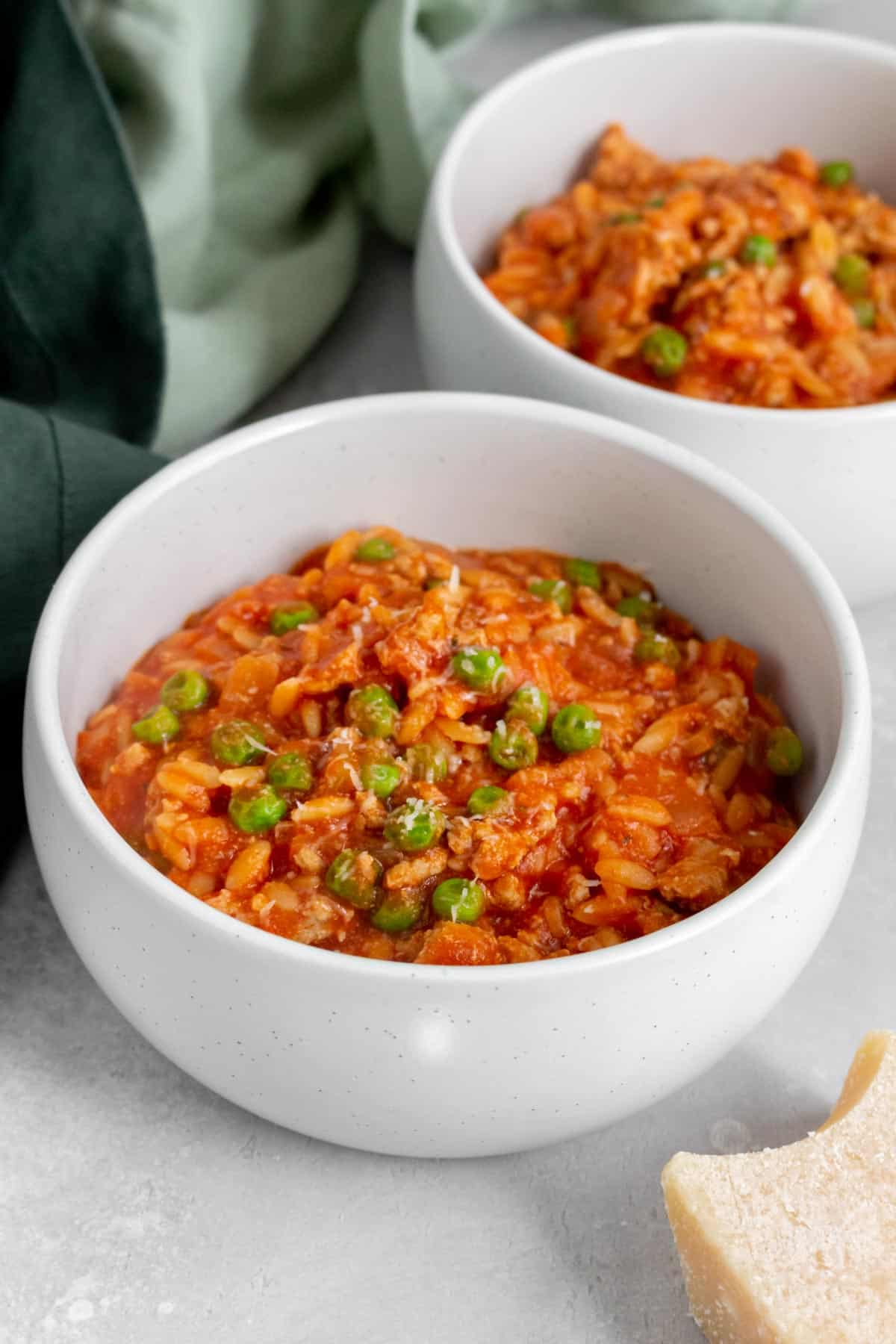 Angled view of a bowl of one pot orzo with turkey and peas.