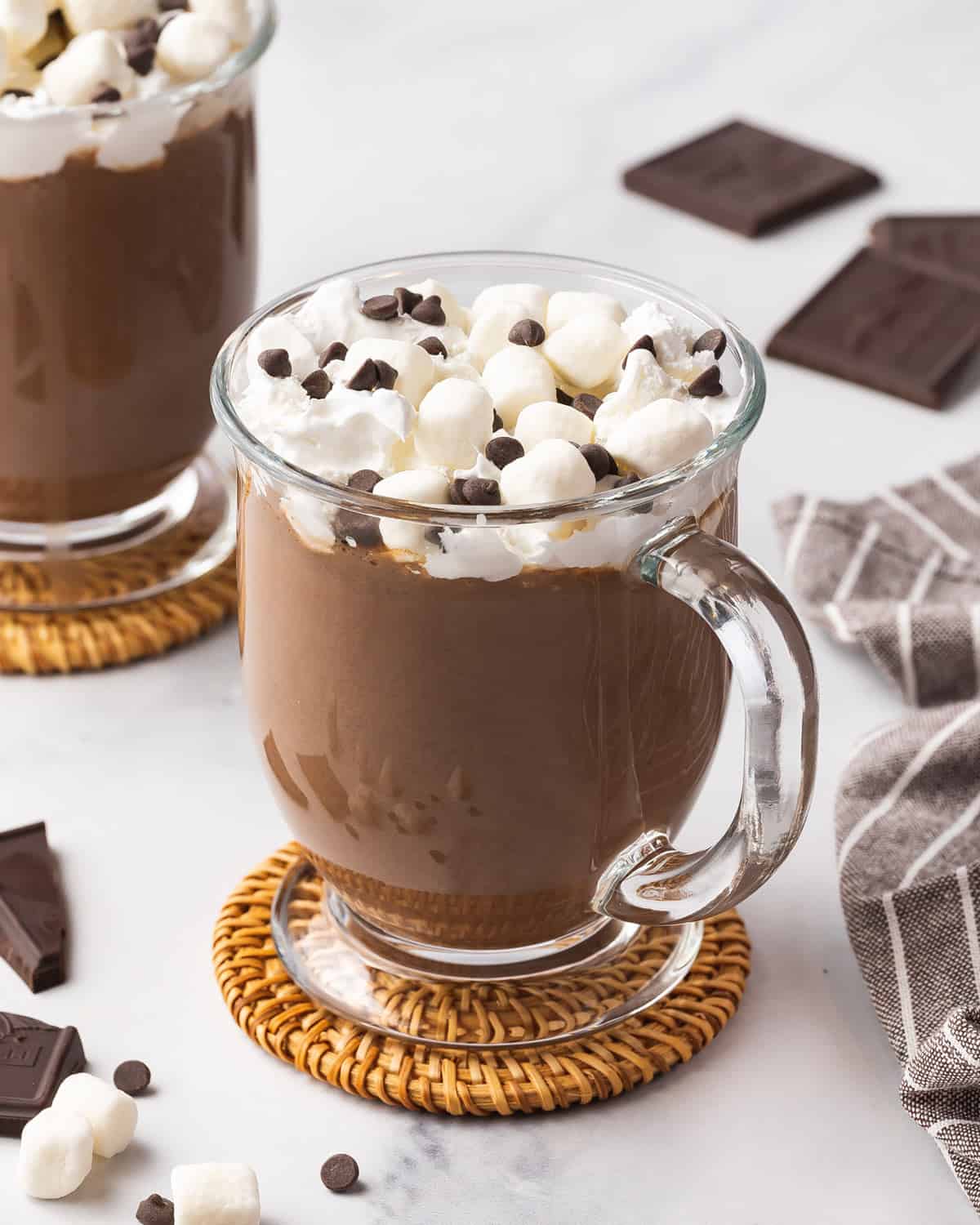 A mug of crockpot hot chocolate with whipped cream, marshmallows, and chocolate chips.