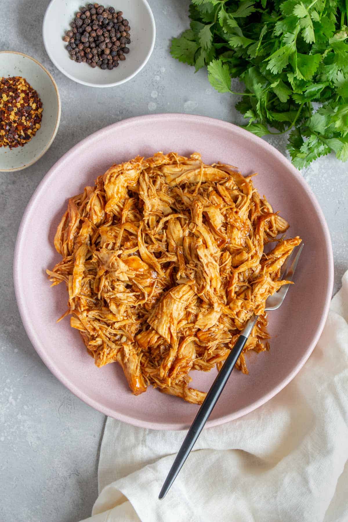Overhead view of a plate of instant pot pulled chicken with a fork.