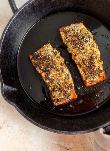 Two everything bagel salmon fillets in a cast iron.