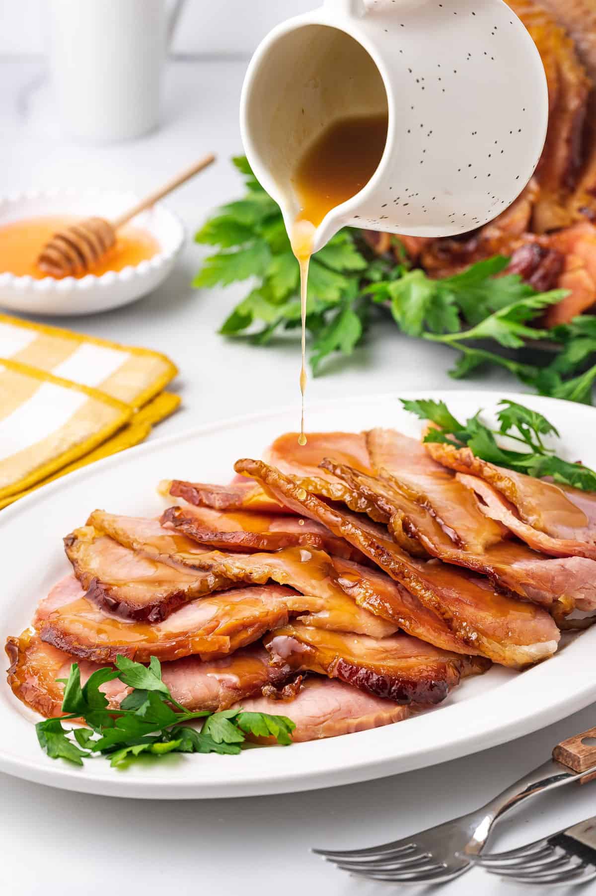 Sauce poured over sliced slow cooker ham on a platter.