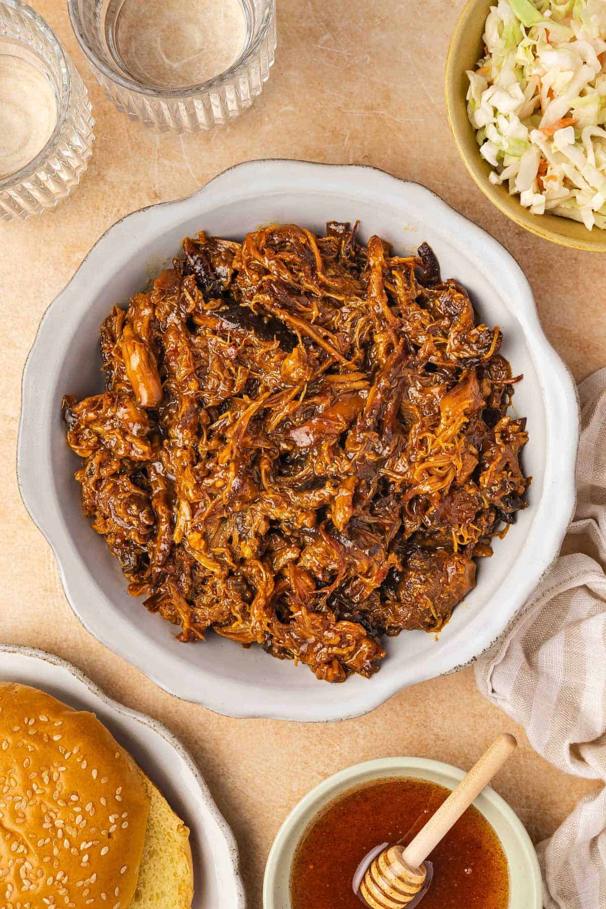 A plate of shredded crockpot slow cooker hot honey chicken thighs.